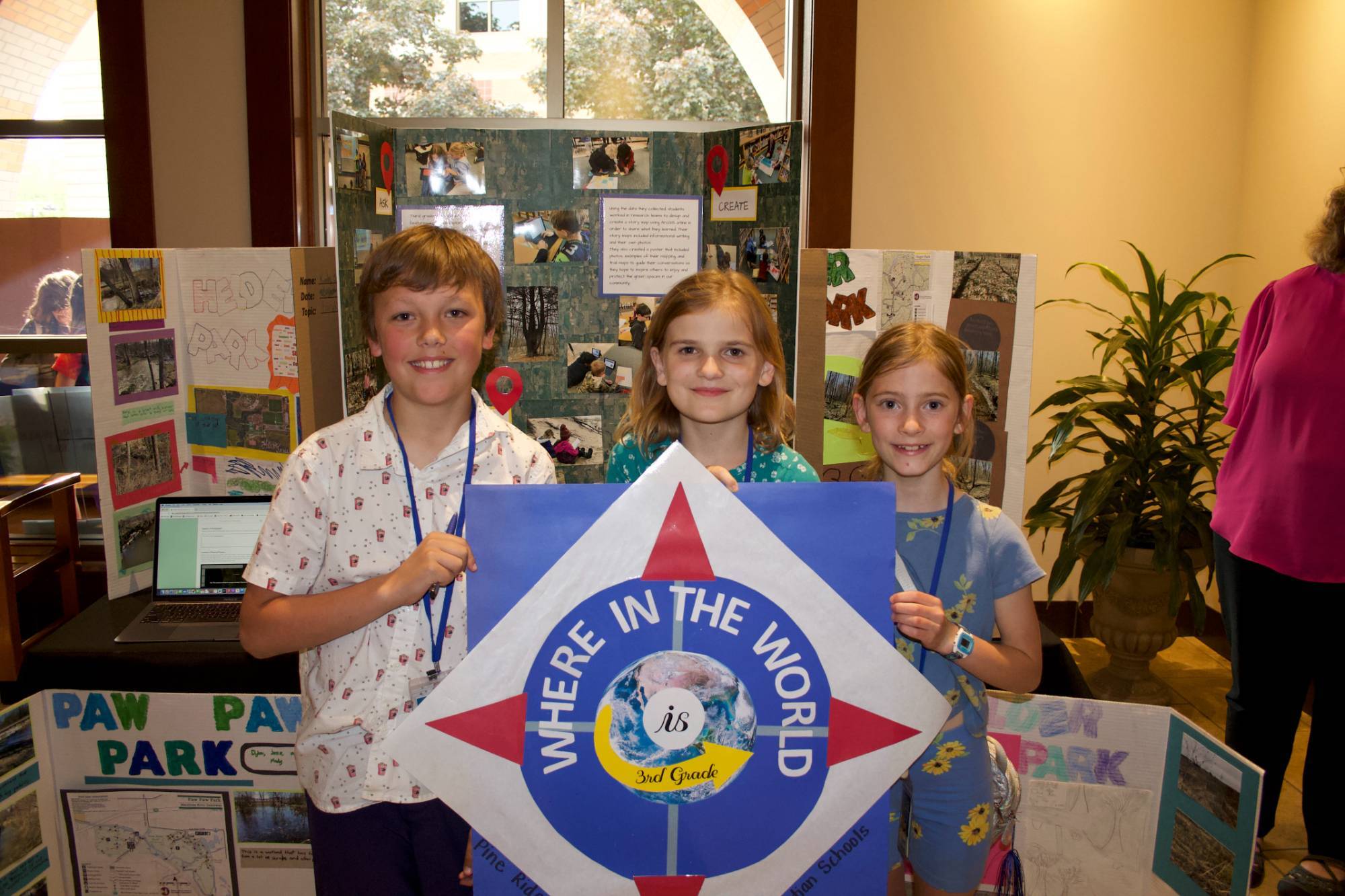 Showcase table exhibit with students standing behind poster presentation